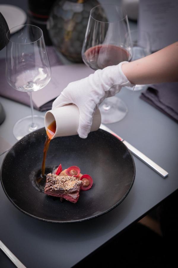 Hotel Maximilian'S اوغسبورغ المظهر الخارجي الصورة A chef pouring a sauce